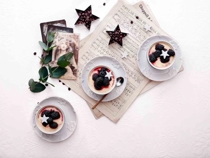 Drei Desserts mit Brombeeren, Sternen und Noten auf einem weißen Tisch
