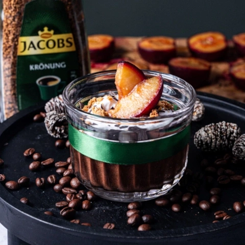 Dessert mit Pflaumen, Kaffee und Jacobs Krönung auf einem Tablett