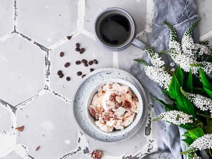 Kaffee, Eiscreme, Blumen und Kaffeebohnen auf einem Tisch
