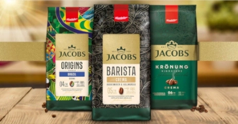 Drei Jacobs Kaffeepackungen auf einem Holztisch.