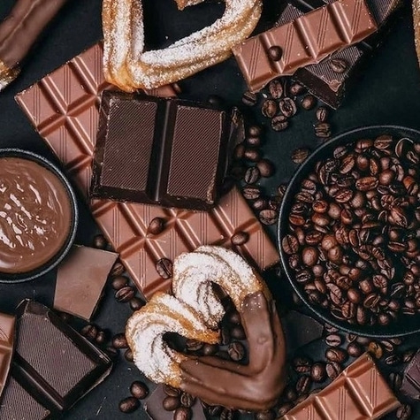Schokolade, Kaffee und Gebäck auf dunklem Hintergrund. Süße Leckereien.
