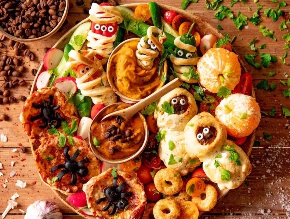 Halloween-Essen: Mumien, Spinnen, Mandarinen, Kürbis-Dip, Kaffeebohnen, Tomaten.